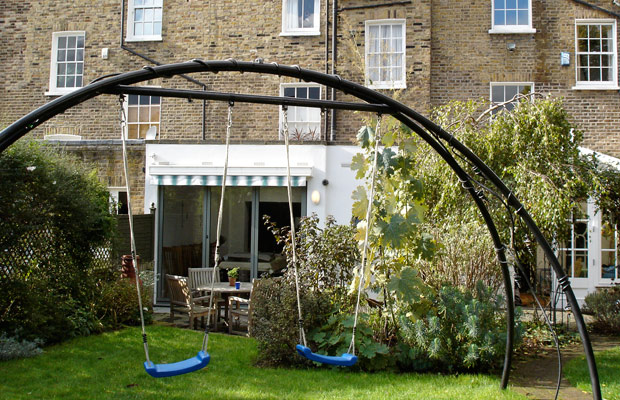 Bespoke ornamental arch converts to swings for the children - Carol Whitehead garden design