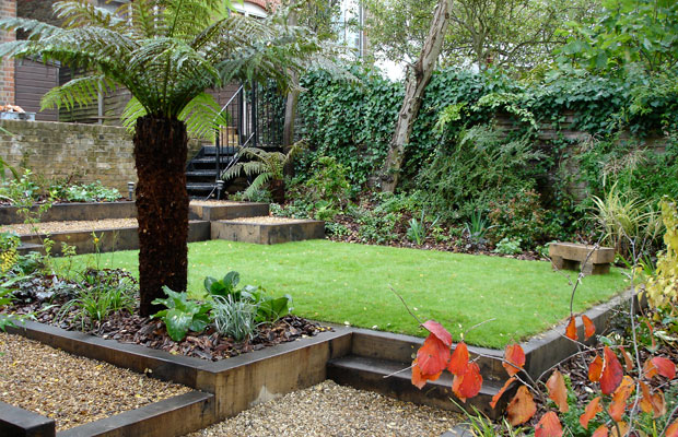 Tree ferns, wooden sleepers and gravel path solve a shady sloping garden - Carol Whitehead garden design