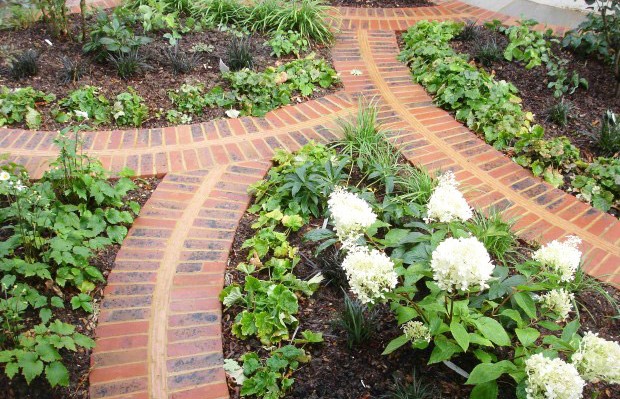 Front garden with art deco style curved brick paths - Carol Whitehead garden design